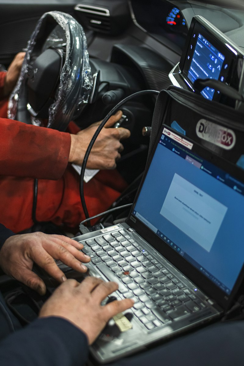 Técnico revisando el sistema del vehículo desde una laptop